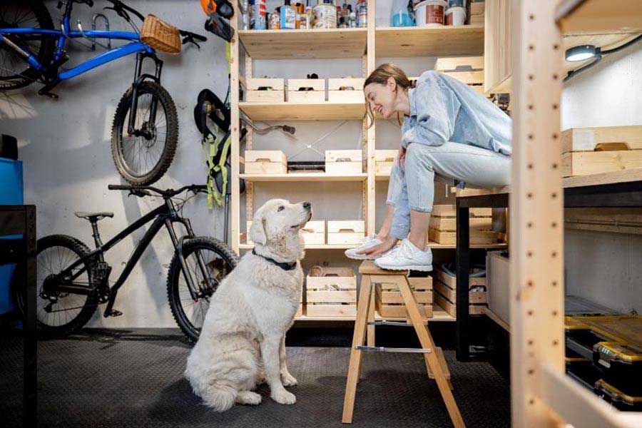 A woman and her dog in a garage