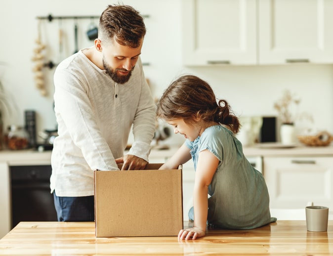 A father and daughter packing a box for a move.