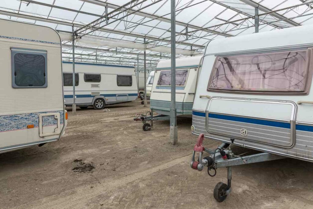 A group of RVs are parked underneath a covered space