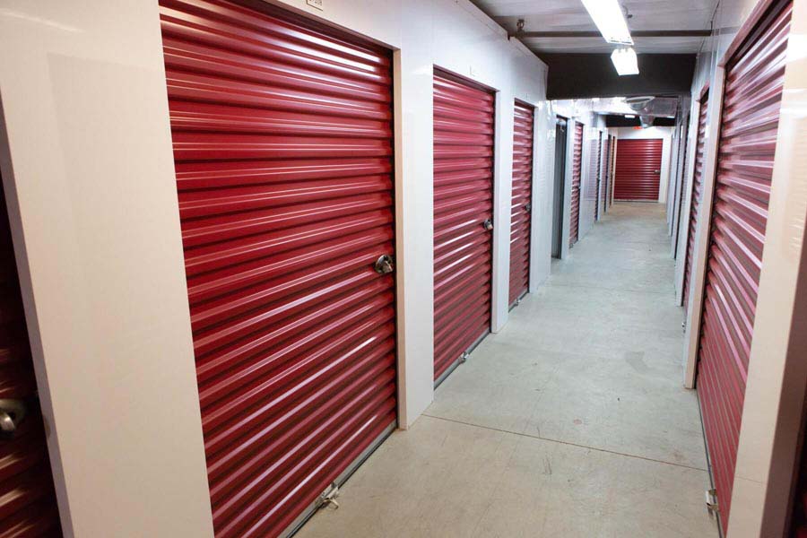 Interior hallway of indoor storage units and their access doors.