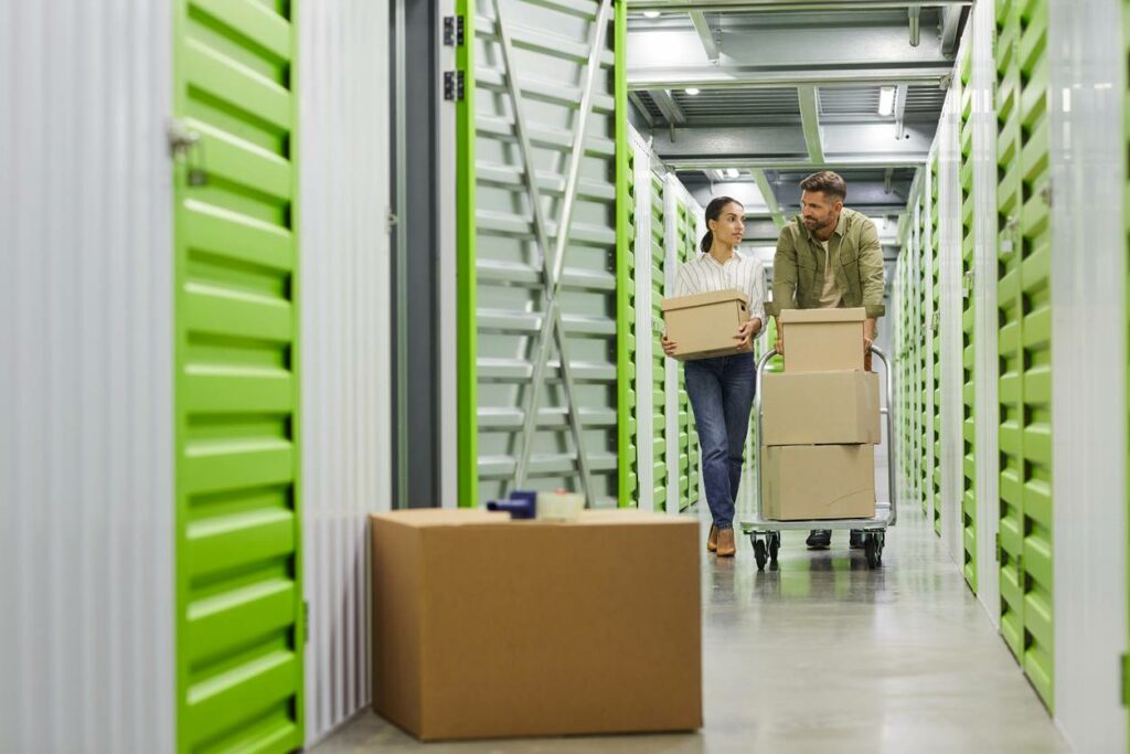 Man and woman moving boxes in self storage unit