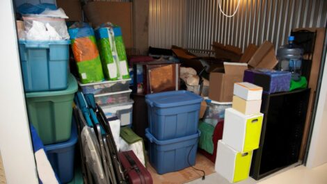 A storage unit filled with tubs, boxes, and various clutter.