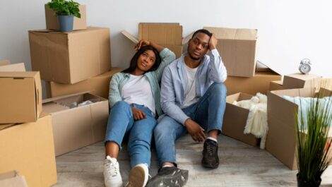 A couple sitting in their living room stressed with moving boxes