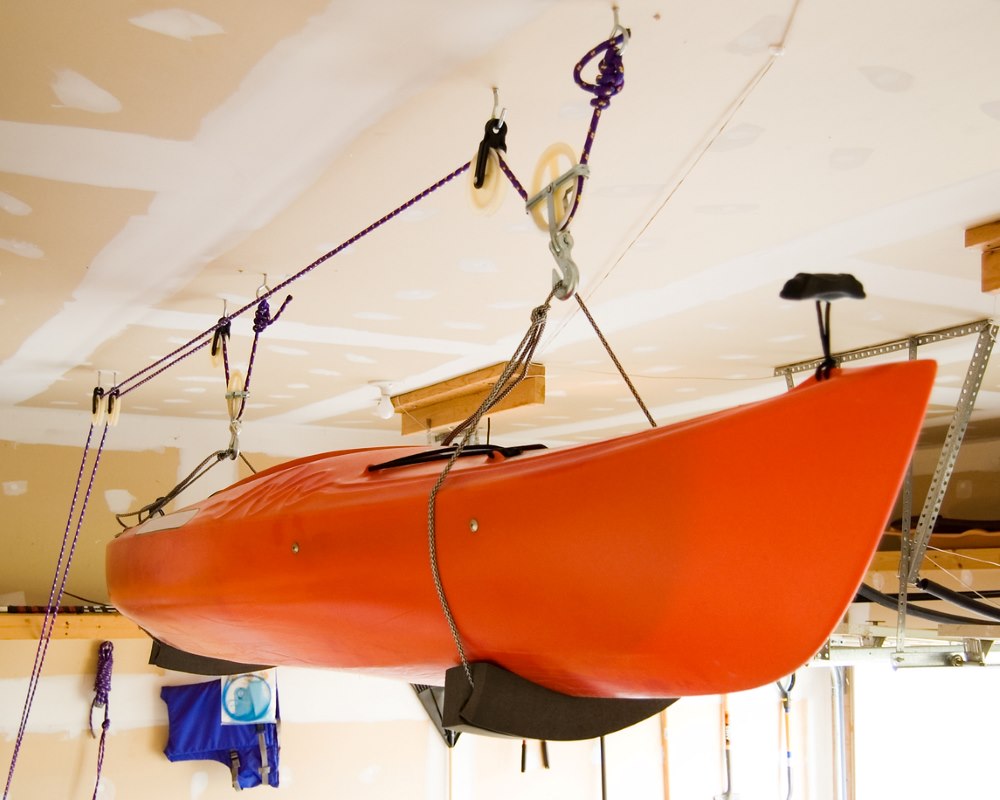 A kayak stored by hanging in a garage