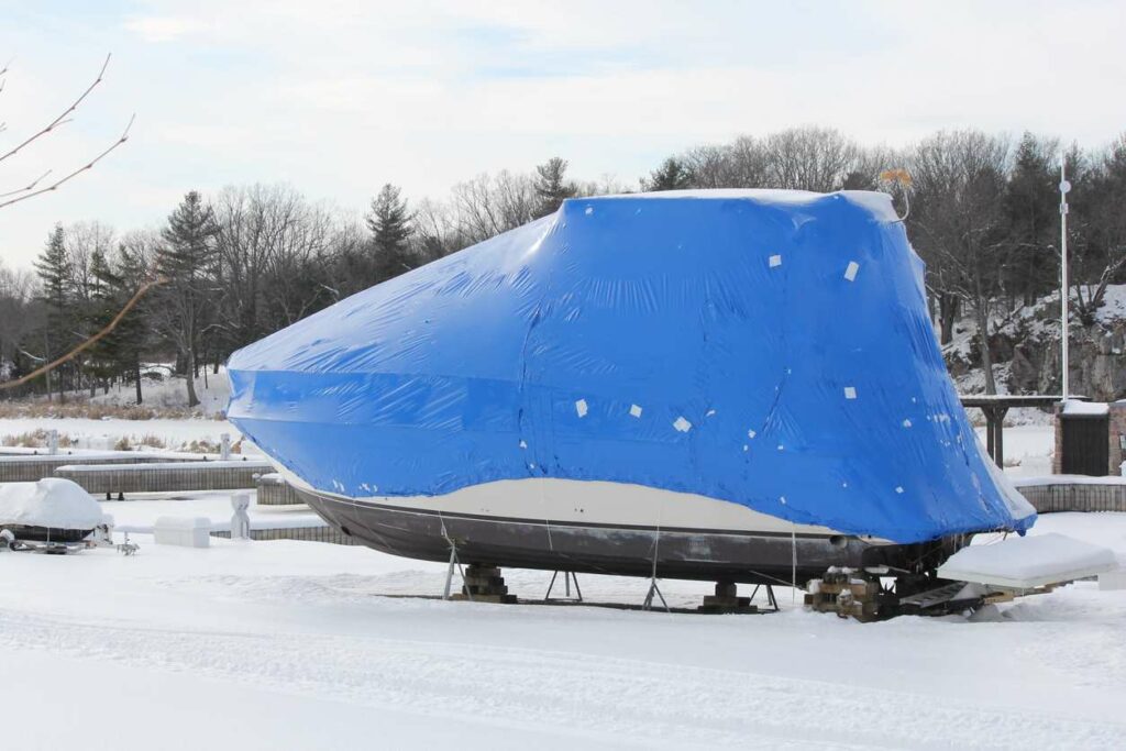 A boat with a tarp on top in the snow