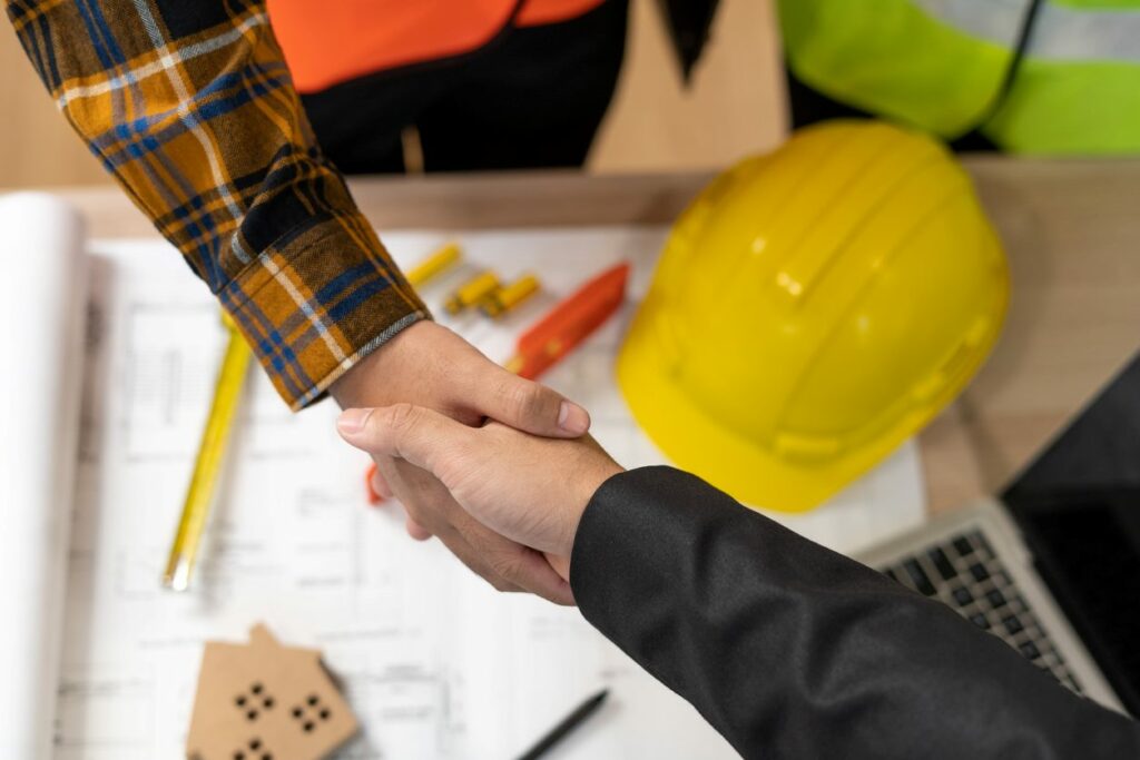A client and contractor shaking hands while working