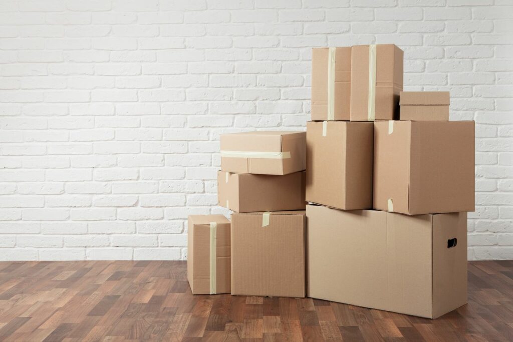 Moving boxes piled in a white room
