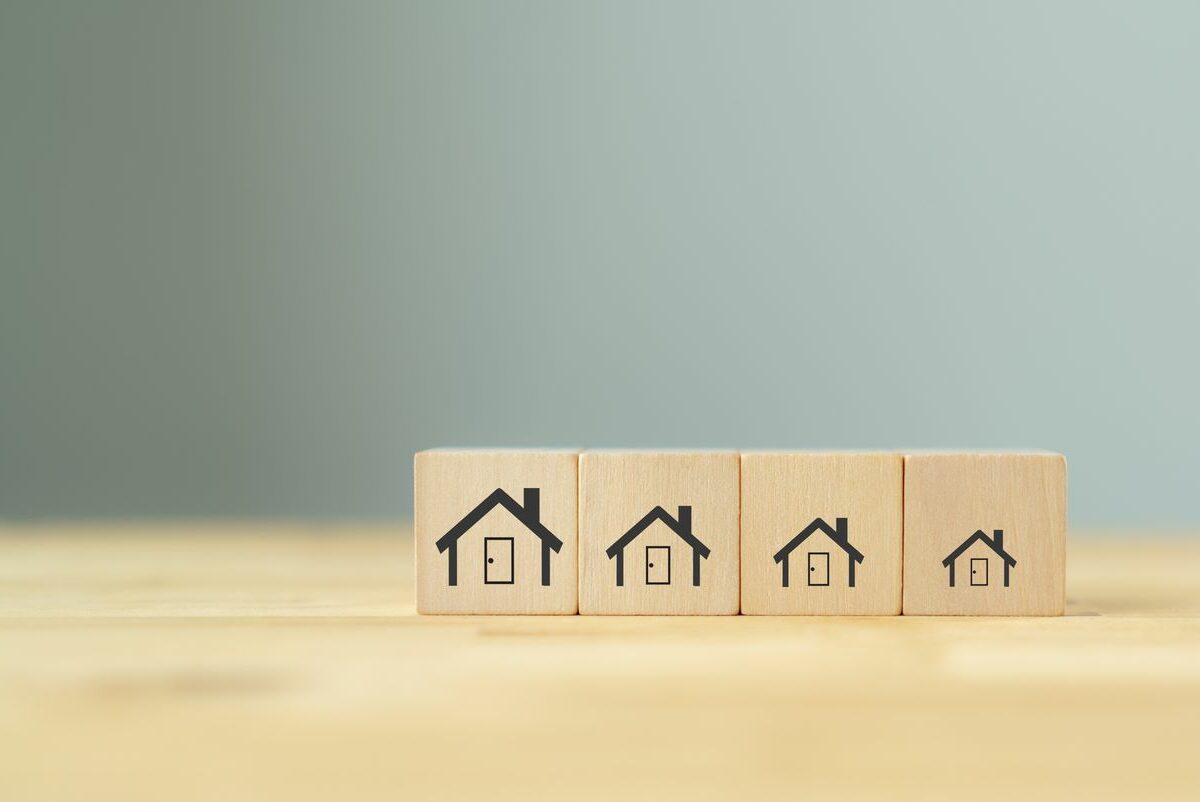 Downsizing homes symbolized through pictures on wooden blocks.