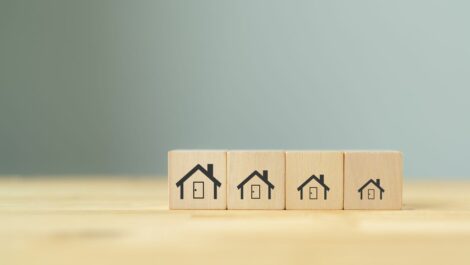 Downsizing homes symbolized through pictures on wooden blocks.