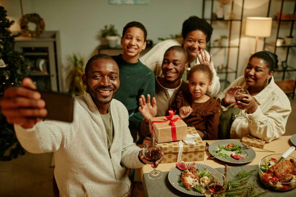 A happy family smiles for a selfie during a Christmas party.