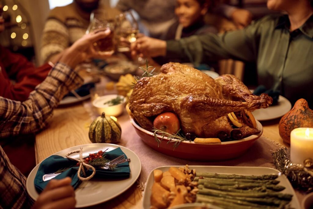 A festive Thanksgiving dinner table with turkey and guests.