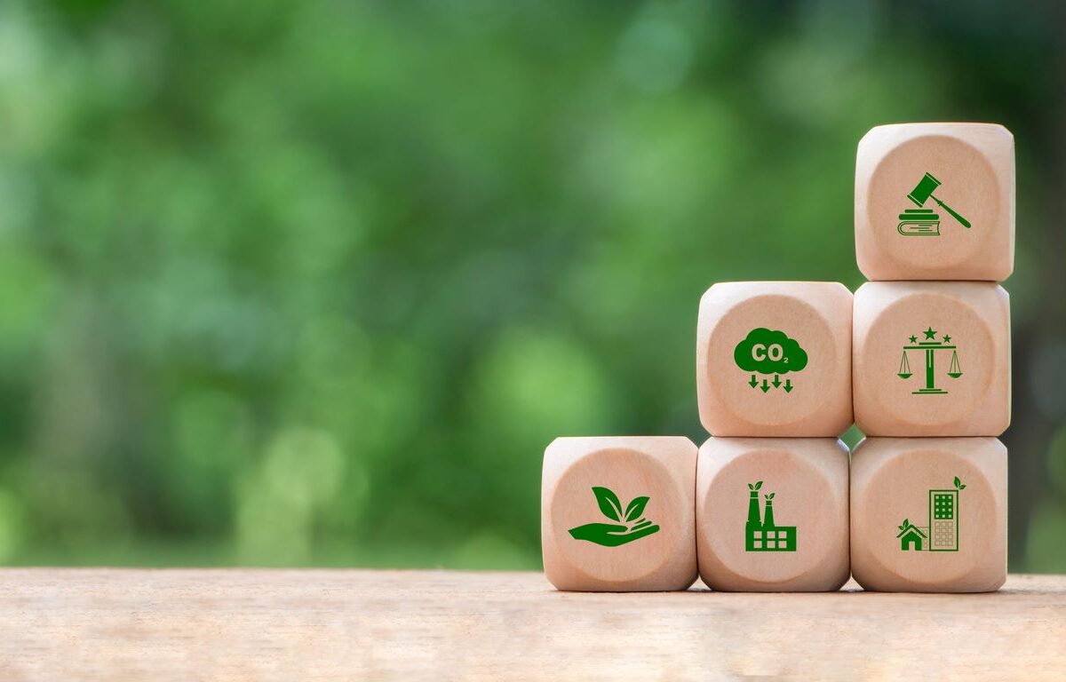 The concept of building blocks with eco-friendly symbols on a wooden table.