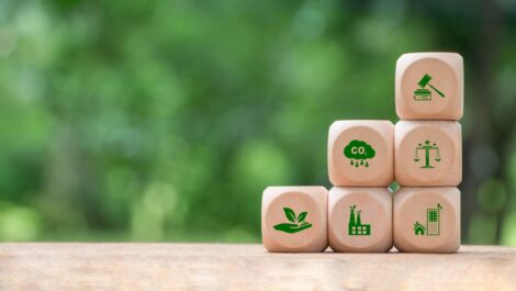 The concept of building blocks with eco-friendly symbols on a wooden table.