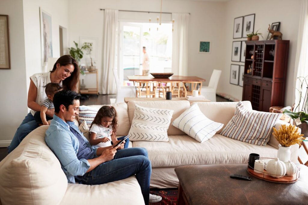 A young family sitting on a sofa reading a book together in the living room