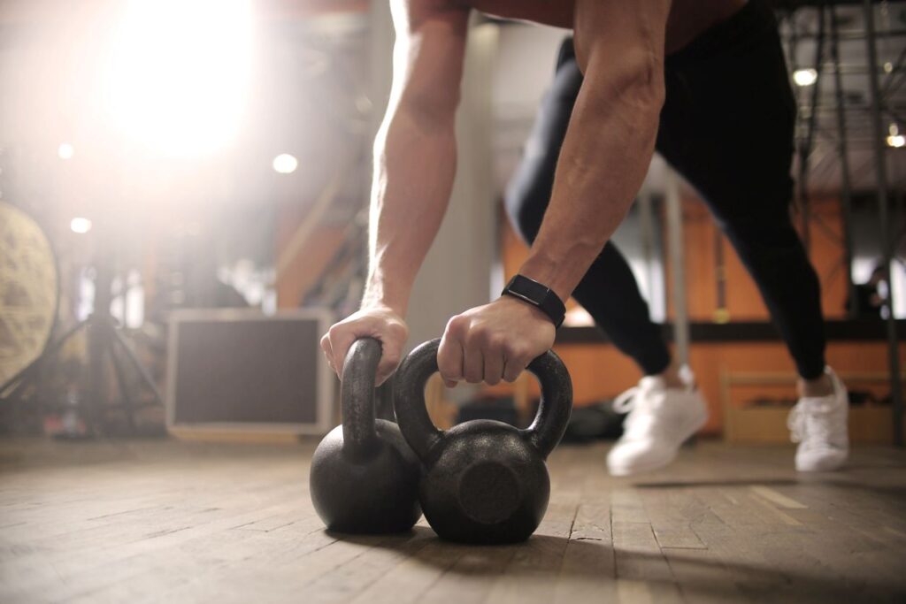 A person doing pushups on a set of kettlebells in their garage