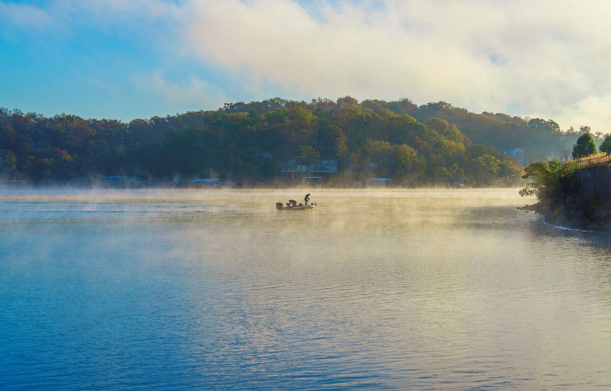An angler fishes on the Lake of the Ozarks on a foggy morning.