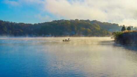 An angler fishes on the Lake of the Ozarks on a foggy morning.